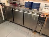 a stainless steel counter with a bunch of cups on it