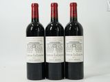 three bottles of red wine sitting next to each other on a table