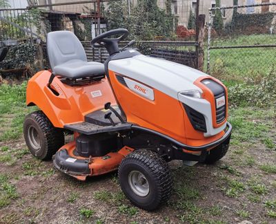 an orange riding lawn mower sitting in the grass
