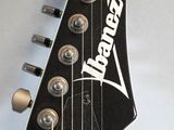 a close up of an electric guitar with a black neck
