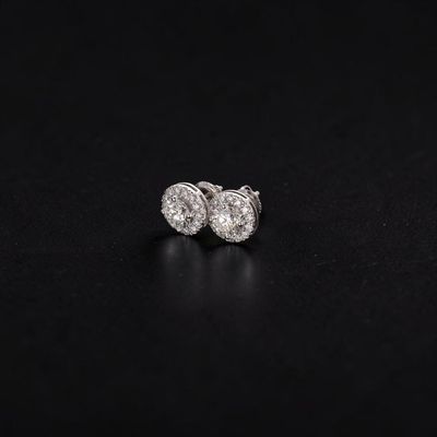a pair of diamond stud earrings on a black background