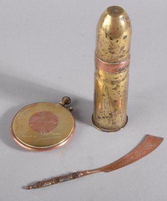 un petit objet en laiton posé à côté d'un couteau et d'une pièce de monnaie