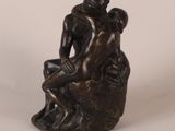 bronze statue of a man and woman sitting on a rock