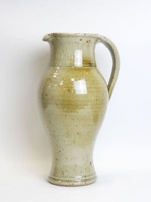 a green vase that is sitting on a white surface