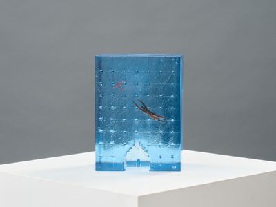 a small glass sculpture on a white pedestal