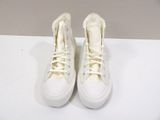 pair of white sneakers with white laces on a white surface