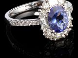 une bague ovale sertie d'un tanzanite et de diamants, posée sur un fond noir