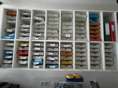 a white shelf with many bins of various items in it