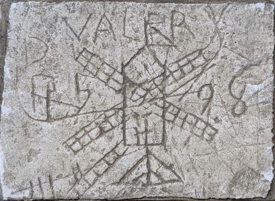 a stone with writing on it on the ground