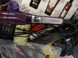 purple hair dryer sitting on top of a pile of hair products