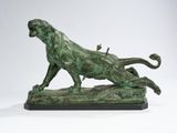 bronze statue of a lion on a rock with a bird on its back