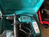 une boîte à outils bleue contenant une perceuse et d'autres outils