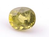 a close up of a yellow sapphire stone on a white surface