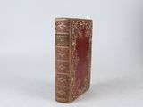 a red book that is sitting on a white surface