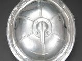 silver plate with a cross on it on a black surface