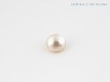 a close up of a single pearl on a white surface
