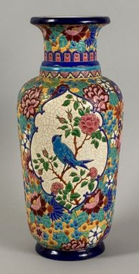 a blue vase with a bird on it sitting on a table
