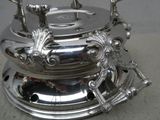 une bouilloire en argent posée sur un plateau en argent, sur une table