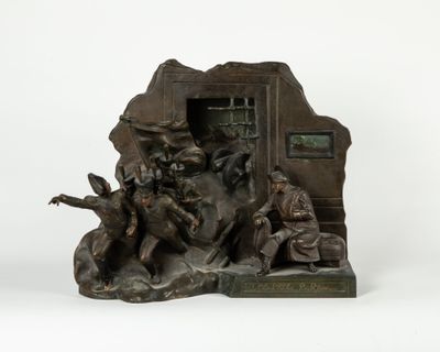 statue représentant un groupe de personnes assises sur un rocher, avec une horloge en arrière-plan