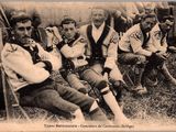 un groupe d'hommes assis sur l'herbe devant une tente