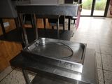 a metal table with a metal pan on it in a restaurant