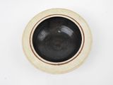 a black and white bowl on a white surface