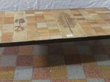 une table sur laquelle est posé un plateau en carrelage