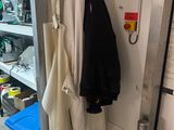 two coats hanging on a rack in a small room