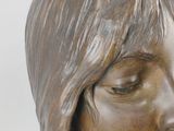 a bronze statue of a woman with long hair