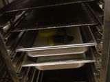 several trays of food sit in an oven on a rack