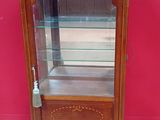 une vieille vitrine en bois surmontée d'une porte vitrée