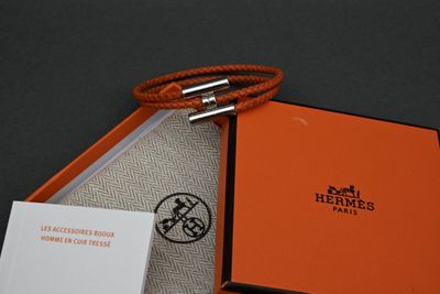 an orange box with a silver clasp and a card in it