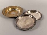 three silver plated dishes sitting on top of a table