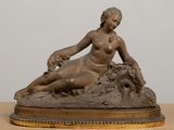 statue of a woman sitting on a rock with a dog in her lap