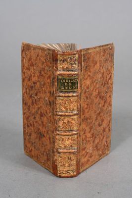 un vieux livre posé sur une table à côté d'un fond gris