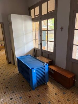 une grande caisse bleue posée dans une pièce, près d'une fenêtre