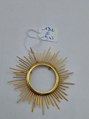 un motif « sunburst » plaqué or sur un fond blanc, avec une étiquette de prix