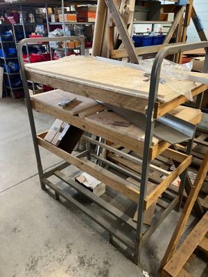 une table en bois posée sur un chariot métallique dans un entrepôt