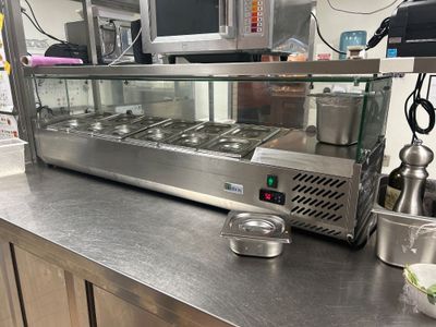 un plan de travail en acier inoxydable sur lequel se trouvent des aliments, dans une cuisine professionnelle