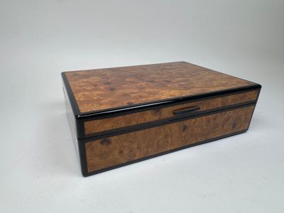 une petite boîte en bois avec une poignée noire sur fond blanc