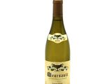 the bottle of white wine is sitting on a white surface