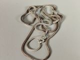 a close up of a silver necklace with a chain attached to it