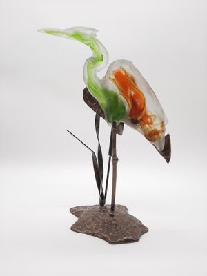 une sculpture en verre représentant un oiseau perché sur un rocher