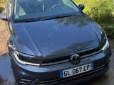 La voiture est garée sur le bord de la route, à côté d'une pompe à essence.