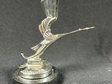statue of a bird on a pedestal on a black background