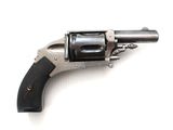un vieux revolver avec une crosse noire sur un fond blanc