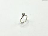 une image d'une bague en diamant sur une surface blanche