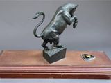 an image of a bronze statue of a lion on a wooden base
