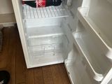 a small refrigerator that is open on the floor