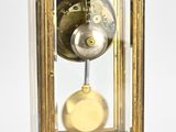 a gold clock with a glass case on top of it